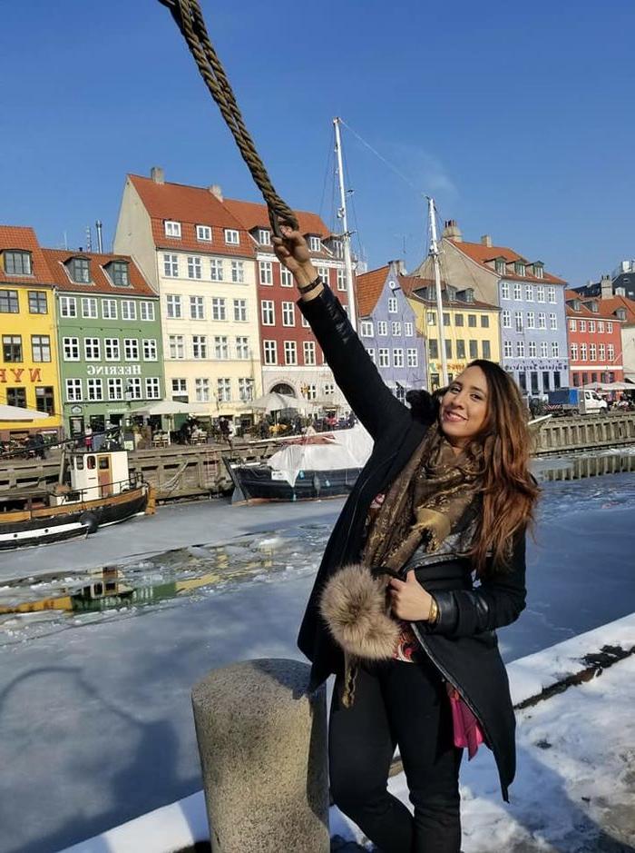 一名年轻女子在丹麦的传统建筑前摆姿势